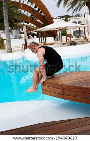 man jumping in to the water near residence with swimming pool