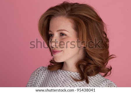 Beautiful redhead woman standing at an angle to the camera gazing off into the distance