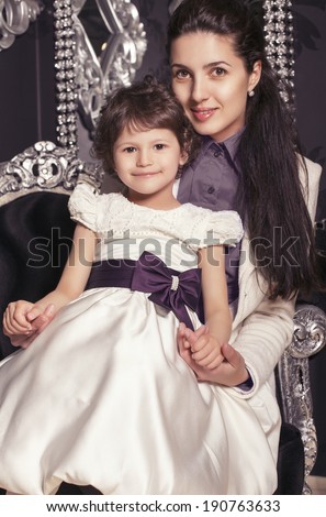 family portrait.little cute girl 5 years old in elegant dress  posing with her mother and home