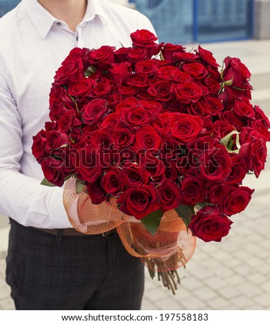 man holding a big bouquet of red roses on Valentine's day