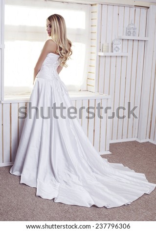 fashion interior photo of beautiful bride with long blond hair wearing luxurious wedding dress posing in studio