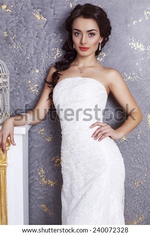 fashion studio photo of beautiful young bride with dark hair in luxurious wedding dress