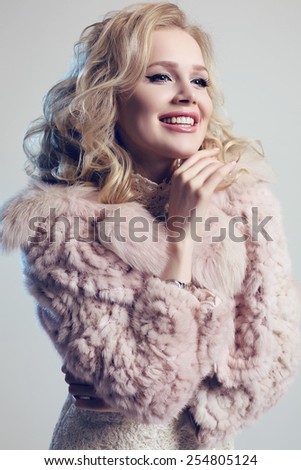 fashion studio photo of gorgeous woman with blond hair wearing  luxurious fur coat  and elegant dress