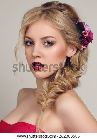 fashion portrait of beautiful sensual woman with blond curly hair with bright makeup and flower\'s hair accessory