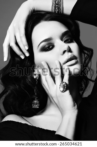 black and white fashion studio photo of beautiful sensual woman with dark hair and bright makeup,with bijou