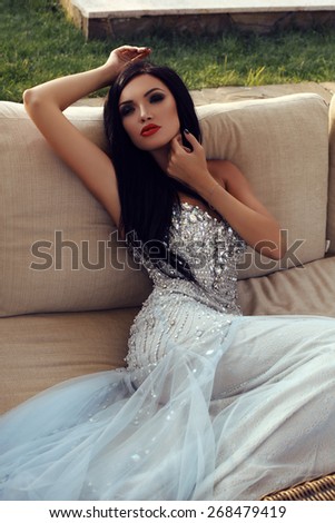 fashion outdoor photo of beautiful sensual woman with dark hair in luxurious sequin dress