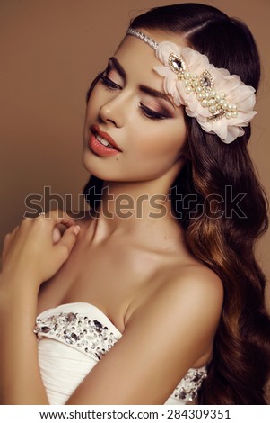 fashion studio portrait of beautiful young girl with dark hair and bright makeup with accessories