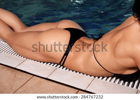 fashion photo of body fitness champion of world cup posing beside a swimming pool