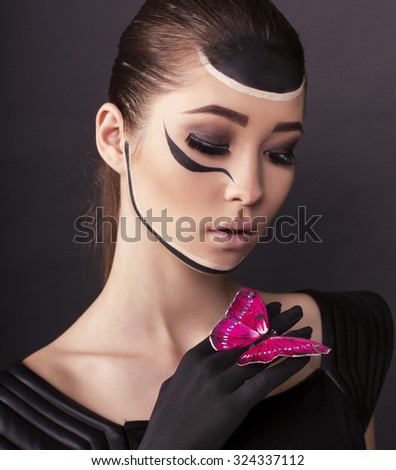fashion studio photo of beautiful asian look woman with dark hair with painted face and butterfly