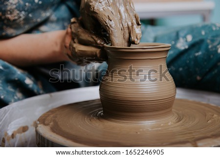Woman hands working on pottery wheel and making a pot. Stockfoto © 