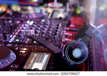 DJ headphones on controller turntable console mixing desk at stage in the night club, music beach party festiva and nightlife concept. Сток-фото © 