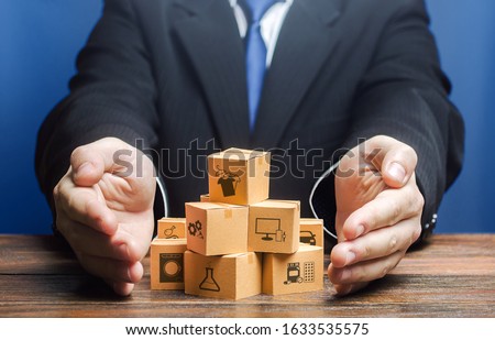 Businessman covers boxes goods. Business management. Commodity circulation import export. Marketing sales, distribution. Support manufacturer, attracting investments, promoting products to new markets 商業照片 © 