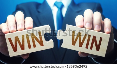 Man holding two puzzles with Win-Win words. A negotiation strategy makes all parties succeed. Mutual benefit and good contract terms. Compromise, perfect. Consent and satisfaction. Trade and diplomacy