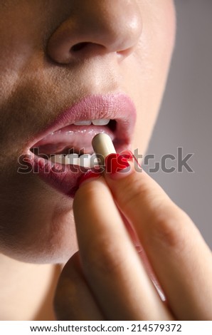 Young woman taking pill for depression