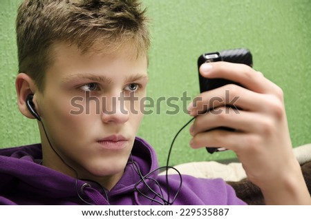Angry lonely teen listening to music and waiting for call heartbroken