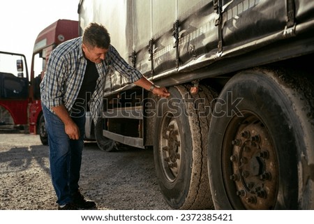 Truck driver checking tires before road  Imagine de stoc © 