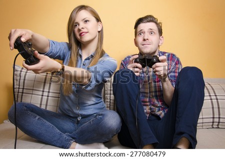 Funny, couple playing video games, girlfriend better then her boyfriend. Selective focus on Girl