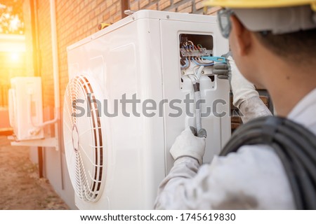 Air Conditioning Technician and A part of preparing to install new air conditioner. Technician vacuum pump evacuates and checking new air conditioner 商業照片 © 