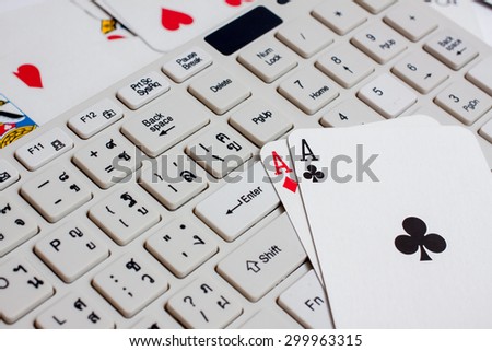 Cards over computer keyboard and smartphone. Concept of online card games.