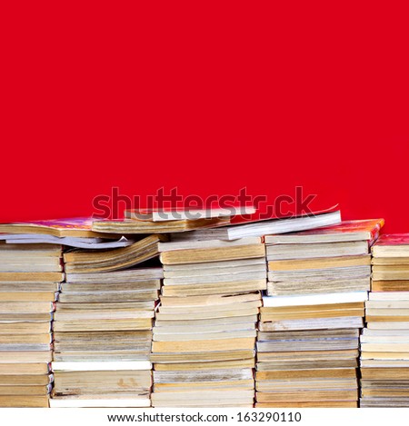 Pile of old books in the library on a red background.