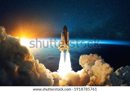 Rocket lift off. Space shuttle with smoke and blast takes off into space on a background of blue planet earth with amazing sunset. Successful start of a space mission. Travel to Mars