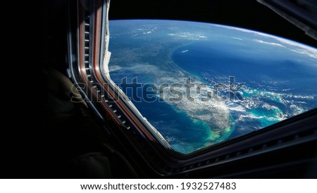 Spaceship flies near the amazing blue planet earth, view from the window. Travel and tourists in space, concept. Beautiful space view of the Earth with cloud formation. Hotel in space