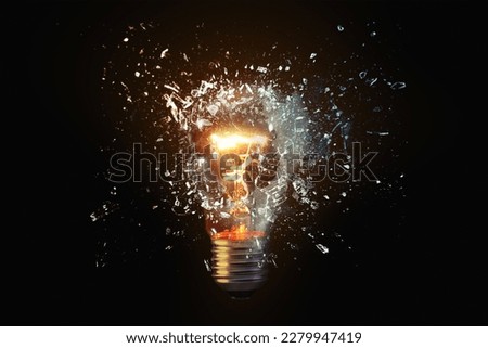 Creative idea light bulb explodes with shards of glass against a dark background. Business, ideas and new thinking, concept. Think Different. Go beyond what is possible. Imagine de stoc © 