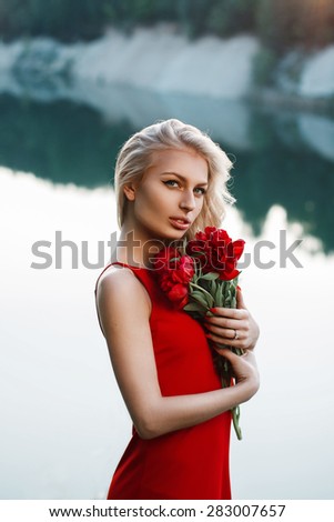 Pretty woman with a bouquet of peony. On the background of the sea.