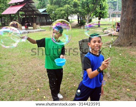 PAHANG, MALAYSIA - SEPTEMBER 6 2015 : Kids playing with giant bubble at local playing ground