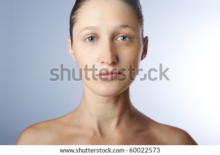 Right part of woman\'s face is serious, other one is smiling. Young woman without any makeup.