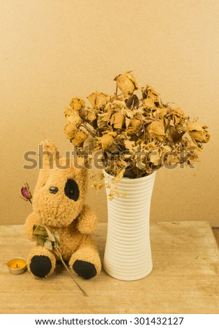Vintage still life . Old wither roses of bear wait for gift someone in the dark room. Lonely time.