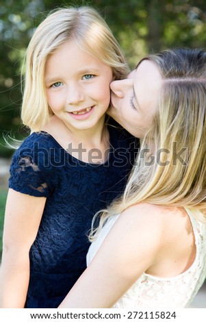 Beautiful Caucasian ethnicity mother kissing her daughter