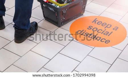 the inscription on the floor of the supermarket: keep a social distance. Selective focus