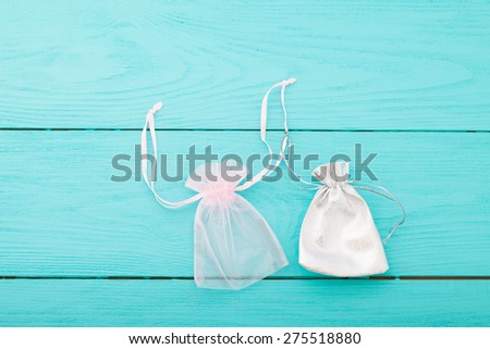 Two jewelry pouches on blue wooden background