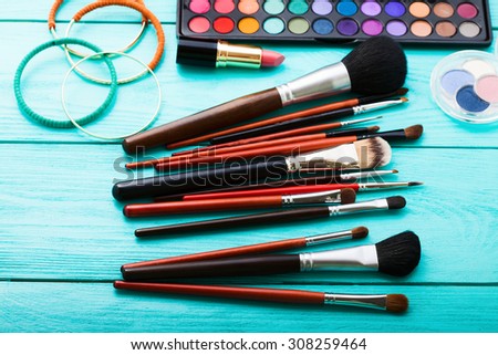 Makeup accessories on blue wooden workspace. Top view