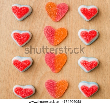 Heart jelly sweets or gummies on wood background. Overhead shot