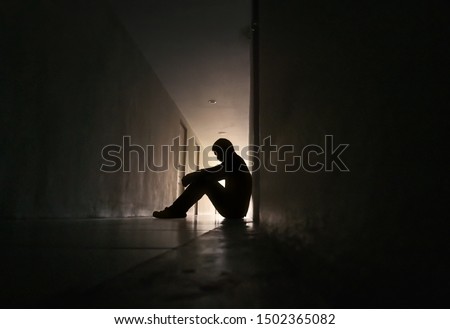 Silhouette of depressed man sitting on walkway of residence building. Sad man, Cry, drama, lonely and unhappy concept. Stock fotó © 
