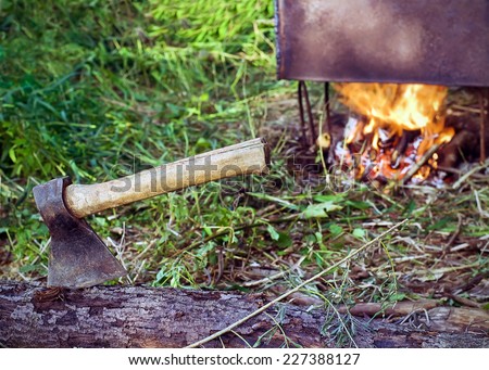 The axe in a log on the background of the smokehouse