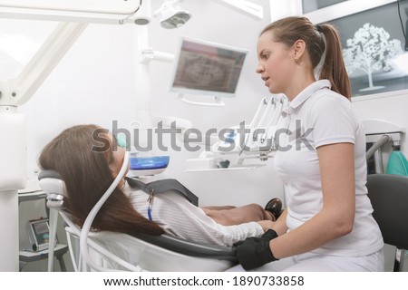 Dentist talking to her patient after putting inhalation sedation face mask on her Stock foto © 