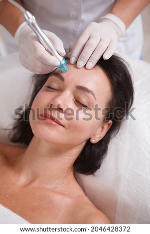 Vertical close up of a woman enjoying hydra pores cleaning procedure by cosmetician Foto stock © 