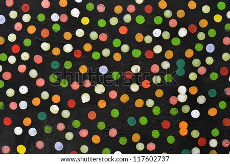 Abstract dotted background, colorful dots painted on the black wall.
