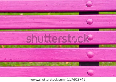 Pink park bench detail, close up image of wooden bars.