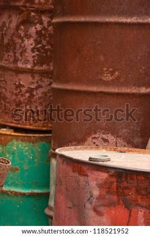 Rusty fuel and chemical drums, corroded barrel pile.