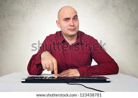 Computer expert sitting at the computer desk, pressing a computer key.