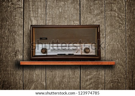 Vintage radio receiver device on wooden shelf