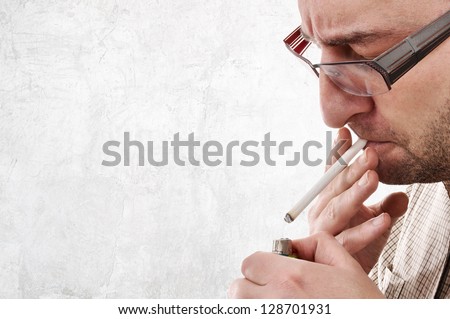 Nervous man lighting a cigarette. Smoking addiction concept.