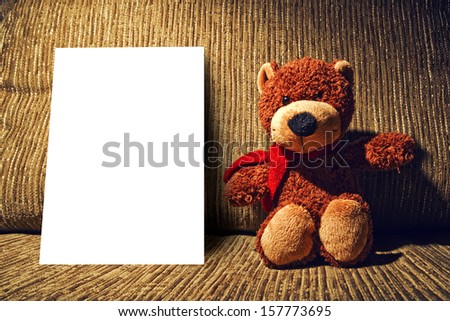 Bear toy on couch with empty business card