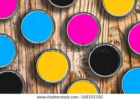 Metal tin cans with four process CMYK colors. Printing industry conceptual background, top view