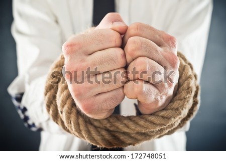 Businessman with hands tied in ropes. Business problems and difficulties, obstructions and limits in work.