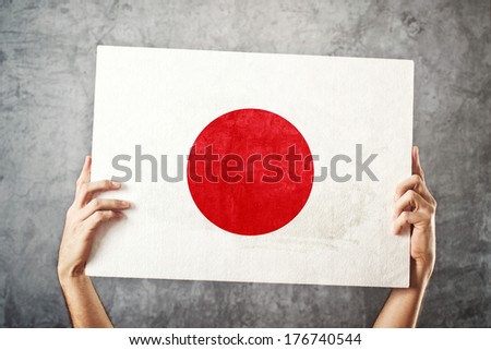 Japan flag. Man holding banner with Japanese Flag. Supporting national team, patriotism concept.